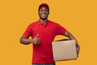 © Prostock-studio - Black delivery man holding cardboard box showing thumb up