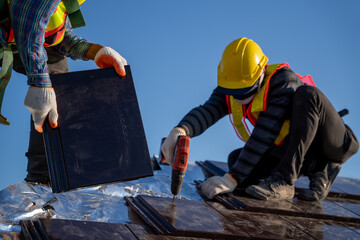 Close up worker install new ceramic tile roof with Roofing tools Electric drill used in the construction site.