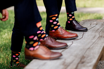 stylish men's socks. Stylish suitcase, men's legs, multicolored socks and new shoes. Concept of style, fashion, beauty and vacation