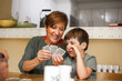 © BASILICOSTUDIO STOCK - Grandson and grandmother talking with complicity while she plays cards.