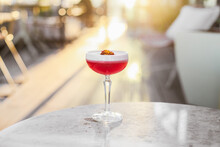 A Red Sour Cocktail On A Marble Table On A Sunny Terrace