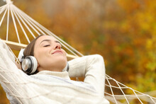 Relaxed Woman Listening To Music With Headphones On Hammock