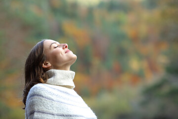 Wall Mural - Woman breathing fresh air in the mountain in winter