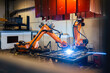 © Westend61 - Orange robotic arms welding in industry