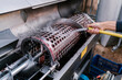 © Ezequiel Gimenez/Westend61 - Hand of worker washing crushing machinery from hose at winery