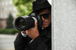 © New Africa - Private detective with modern camera spying outdoors, focus on lens