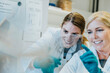 © Mareen Fischinger/Westend61 - Smiling scientist and assistant discussing while examining human brain microscope slide at laboratory