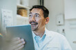 © Mareen Fischinger/Westend61 - Smiling scientist using digital tablet while sitting at laboratory