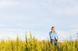 © William Perugini/Westend61 - Male engineer talking through mobile phone and document while standing against wind turbines on field