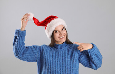 Sticker - Pretty woman in Santa hat and blue sweater on grey background