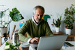 © VALENTINA BARRETO STUDIO/Westend61 - Mature man working on laptop while sitting at home
