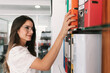 © MORNINGVIEW AGENCY/Westend61 - Businesswoman taking file from shelf while standing at office