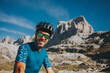 © Photographer: David Molina Grande/Westend61 - Smiling mid adult male cyclist wearing cycling helmet and sunglasses at Picos de Europa National Park, Cantabria, Spain