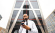 © Jose Carlos Ichiro/Westend61 - Bearded businessman using smart phone in front of modern skyscraper
