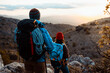 © Rafa Cort√©s/Westend61 - Couple with backpacks looking at view while hiking on mountain during sunset