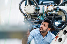 Male Entrepreneur Concentrating While Analyzing Machine Part In Manufacturing Factory