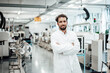 © KNSY/Westend61 - Male scientist wearing lab coat while standing with arms crossed at bright laboratory