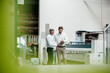 © KNSY/Westend61 - Male engineer discussing with colleague over digital tablet in industry