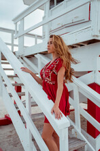 Long Hair Woman Looking Away While Standing On Steps Of Lifeguard Hut At Beach