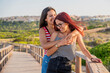 © Javier De La Torre Sebastian/Westend61 - Cheerful teenage girls embracing on boardwalk at beach against clear sky