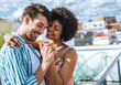 © klublu/Westend61 - Pretty interracial couple on roof holding hands and laughing