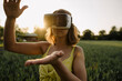 © KNSY/Westend61 - Young woman wearing VR goggles in a grain field in the countryside