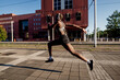 © Eugenio Marongiu/Westend61 - Female athlete with shaved head listening music through headphones while running on street in city