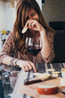 © Arno Studio/Westend61 - Cheerful young woman holding cracker while sitting at dining table