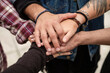 © Tetra Images/Tetra Images - Stack of hands, friends holding hands outdoors