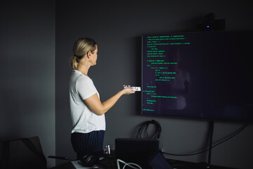 Side view of IT professional working on projection screen in creative office