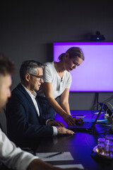 Female IT professional working on laptop by male colleague at workplace