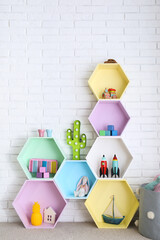 Sticker - Child room interior with colorful shelves near brick wall