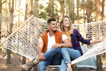 Happy couple resting in hammock outdoors on summer day