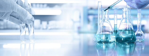 Wall Mural - hand of scientist with test tube and flask in medical chemistry lab banner background