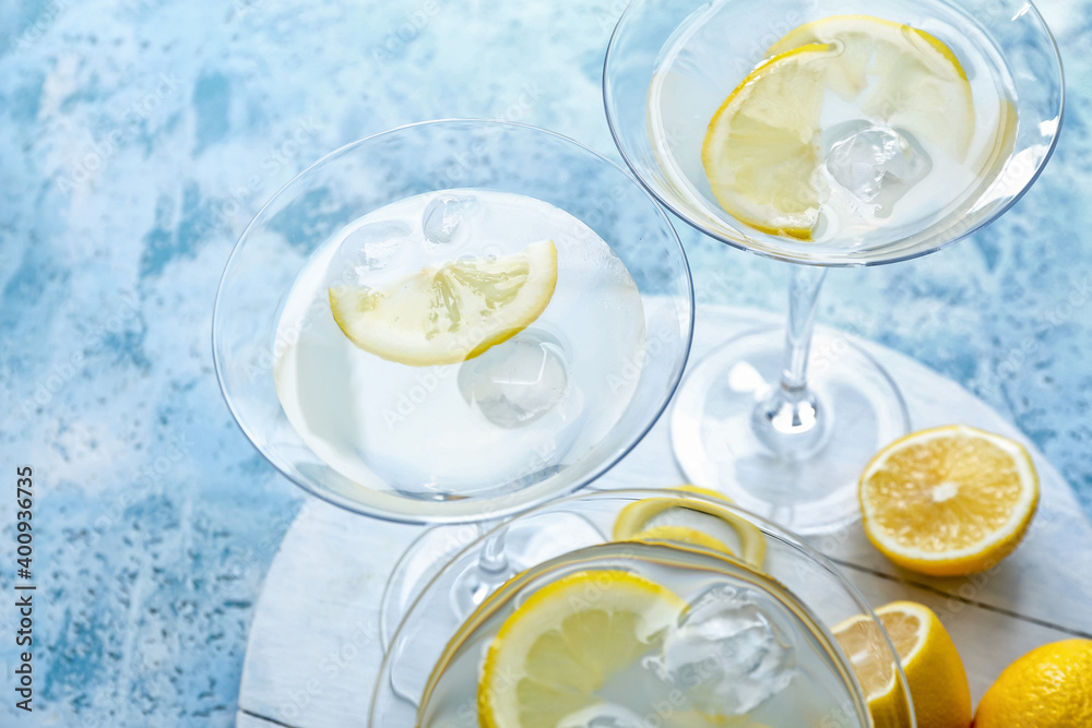 Glasses of fresh martini on color background