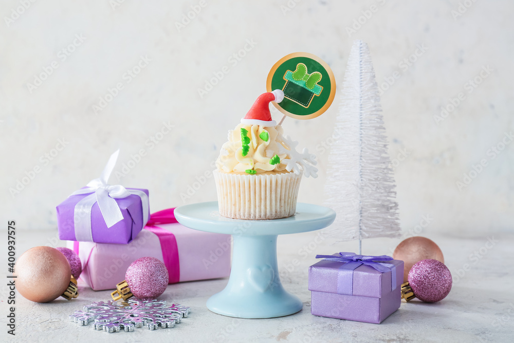 Dessert stand with tasty Christmas cupcake on table