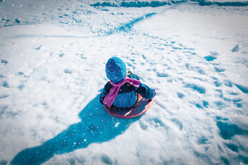 Canvas Print - kids winter fun- little girl sliding in winter snow