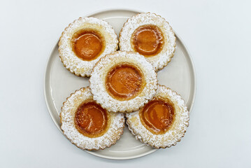 Round cookies with fruit jam and icing sugar, italian occhi di bue, isolated on white background. 