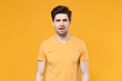 © ViDi Studio - Young disgusted confused displeased unshaved caucasian handsome man 20s years old wearing casual basic blank print design t-shirt looking camera isolated on yellow color background studio portrait.