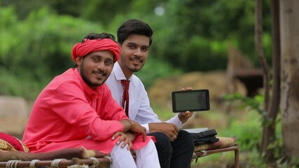 Wall Mural - indian farmer and agronomist or banker showing smartphone at home