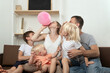 © somemeans - Large family at home preparing for the holiday and inflating balloon.