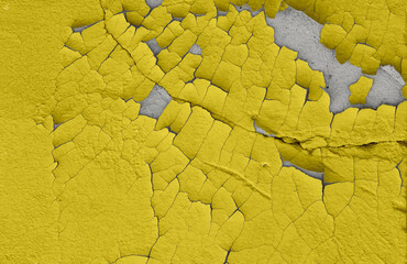 Cracked illuminating yellow paint on an old cement wall. The old background is painted illuminating yellow on the walls. Illuminating yellow color