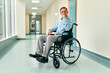 © Valerii Apetroaiei - A sad, upset elderly disabled man in a wheelchair sits in the middle of a clinic corridor waiting for his family.