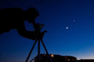 Wall Mural - silhouette of a astronomy telescope and amateur astronomer with stars on the sky.