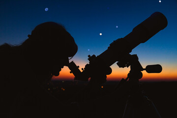 Wall Mural - woman looking at night sky with amateur astronomical telescope.