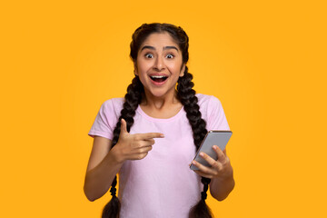 excited indian woman using mobile phone, celebrating online win