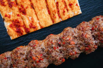 Wall Mural - Traditional Turkish grilled shish kebab or kebap. Delicious Adana kebab on black background.