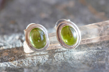 pair of sterling silver olivine mineral stone earrings on natural background