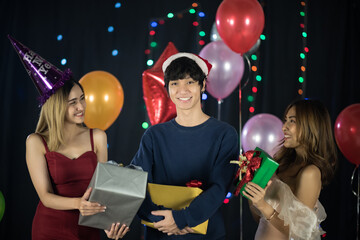 group of Asian people friends celebrating with gift box in party of new years 2021 and Christmas