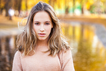 young beautiful blonde girl in beige sweater